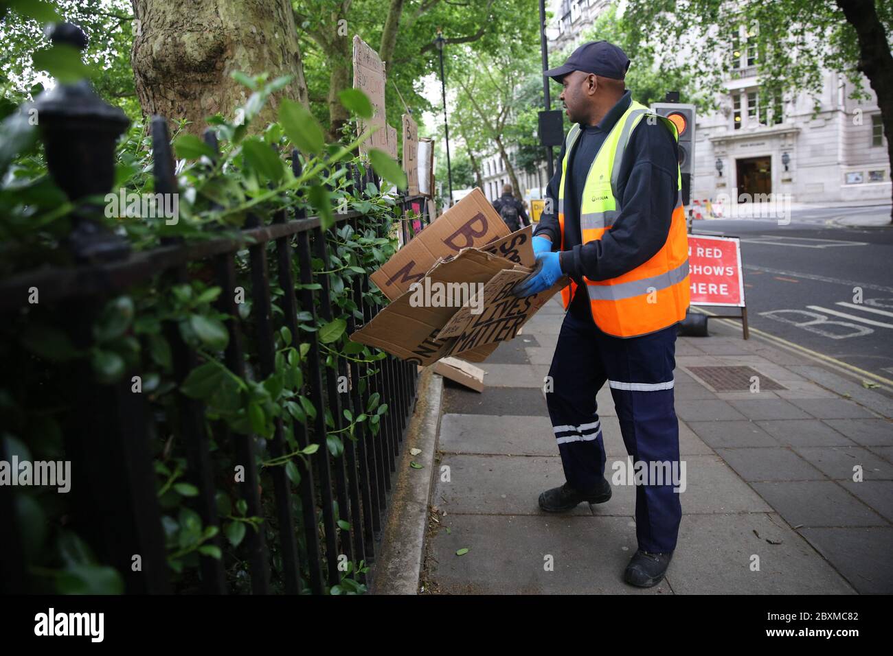 A worker collects discarded placards from Victoria Tower Gardens in Westminster, London, following a Black Lives Matter protest at the weekend. A raft of protests across the UK were sparked by the death of George Floyd, who was killed on May 25 while in police custody in the US city of Minneapolis. Stock Photo