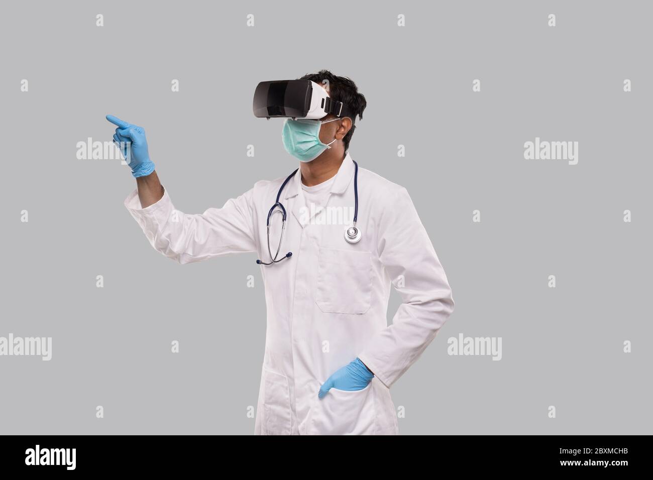 Doctor Wearing VR Glasses, Medical Mask and Gloves Tapping Isolated. Indian  Man Doctor Pointing in Virtual Reality Stock Photo - Alamy