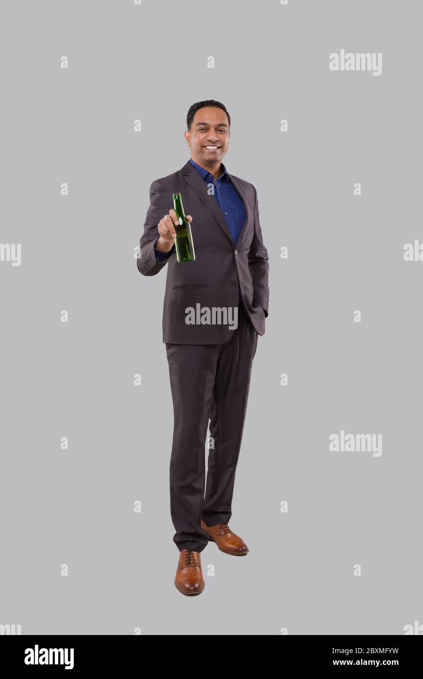 Businessman Holding Beer Bottle. Indian Businessman Standing Full Length. Stock Photo
