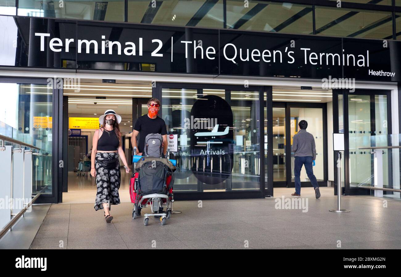 Passengers Guy Potter and Sarah Hartstein arrive at Terminal 2 at Heathrow Airport in London, as new quarantine measures for international arrivals come into force. Stock Photo