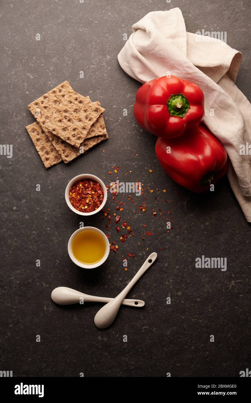 Olive oil with chili peppers in pieces, olive oil, red peppers and crackers, on a dark background Stock Photo