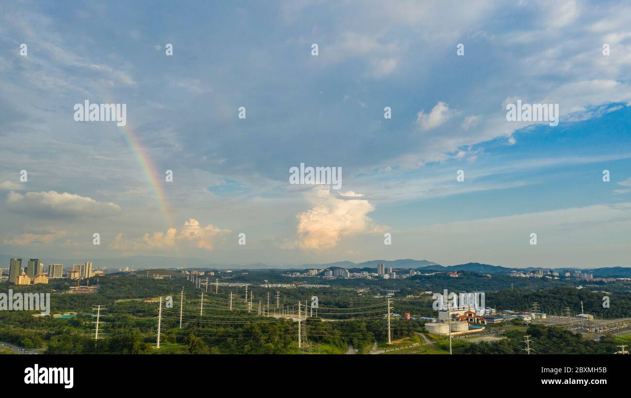 Aerial view of suburban landscape of Kuala Lumpur, Malaysia with visible rainbow and cloudy sky. Stock Photo