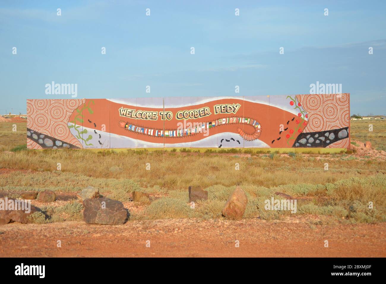Aboriginal style long painted sign at the entrance to the outback opal mining town of Coober Pedy in Australia Stock Photo
