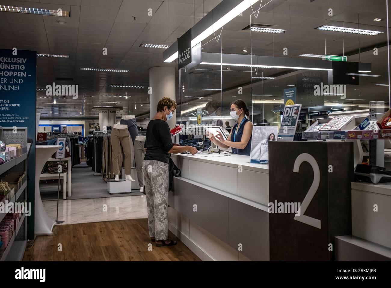 Shoppers in a Kaufhof department store in Braunschweig wearing mandatory face masks after the coronavirus lockdown was lifted, north-central Germany. Stock Photo