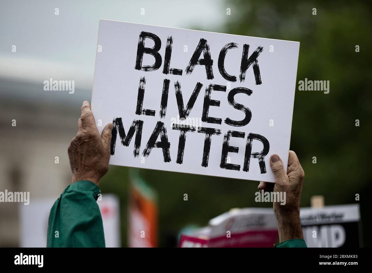 A person holding a black lives matter banner at a protest Stock Photo