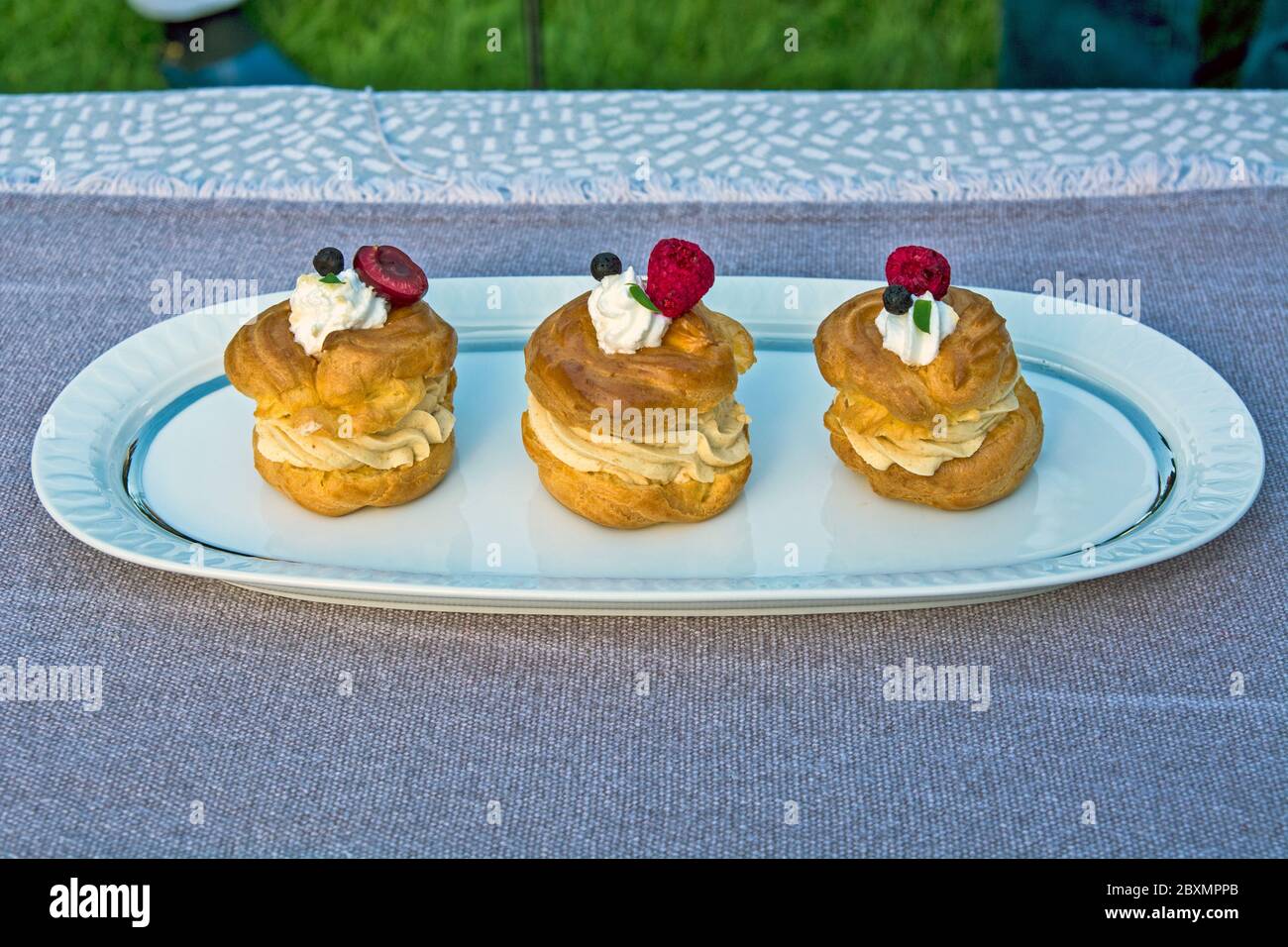 Three princess donuts on a plate with sweet fruit decorations on them. Stock Photo