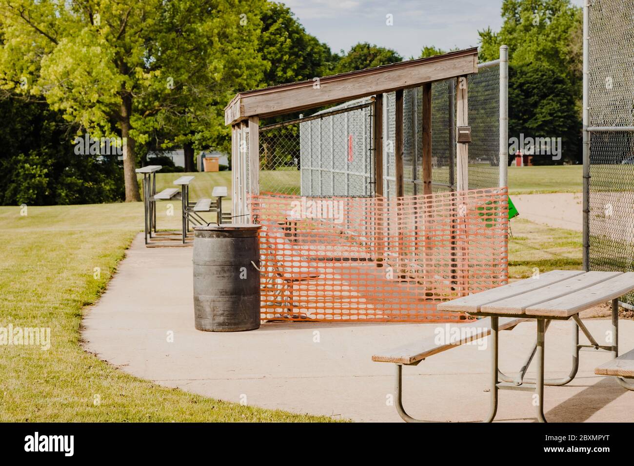 the dugouts on this baseball field are closed by city order in this city park field Stock Photo
