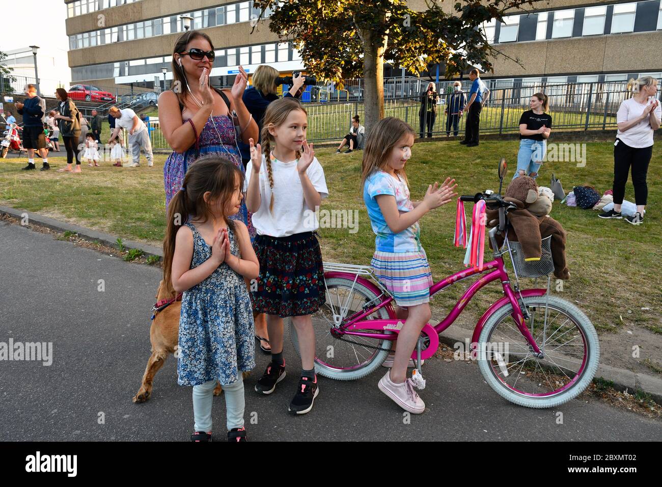 Young family from neighbourhood clapping support for nurses at Thursday 8pm clap for carers during Coronavirus lockdown, Royal Berkshire Hospital, UK Stock Photo