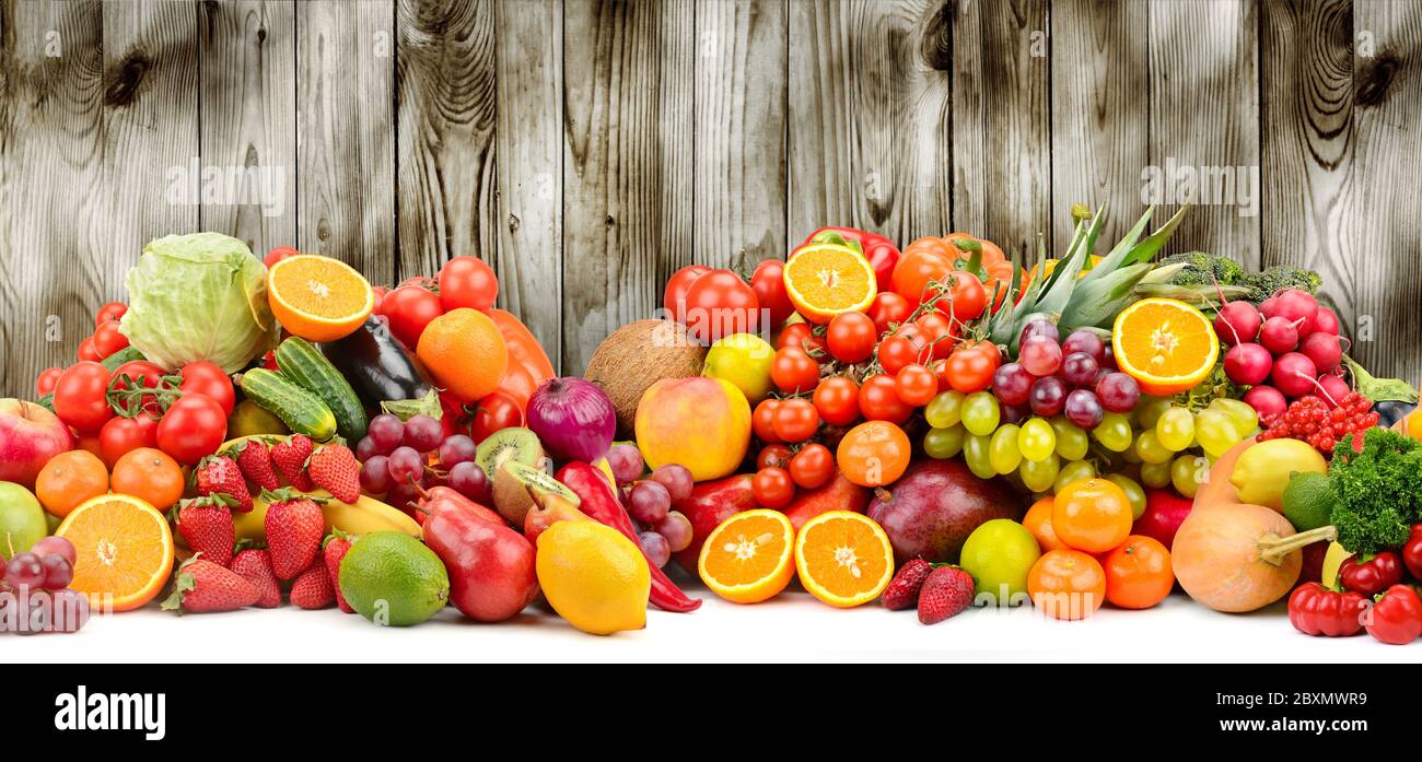 Different fruits and vegetables on dark wooden background for kitchen