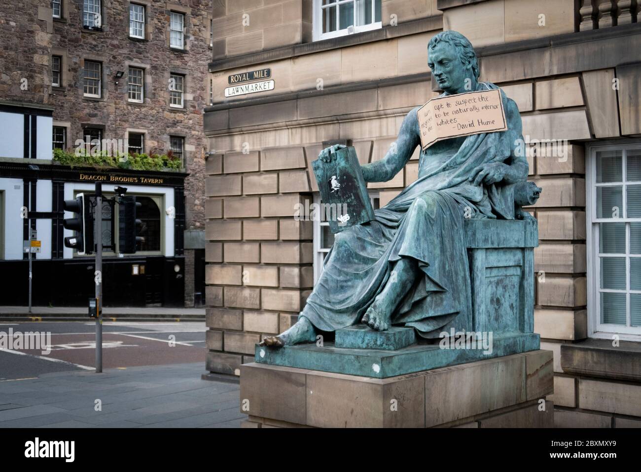 A poster hangs from the statue of the 18th Century philosopher David Hume on the Royal Mile, Edinburgh, following the Black Lives Matter protest rally on June 7, 2020, in Holyrood Park, Edinburgh, in memory of George Floyd who was killed on May 25 while in police custody in the US city of Minneapolis. Stock Photo