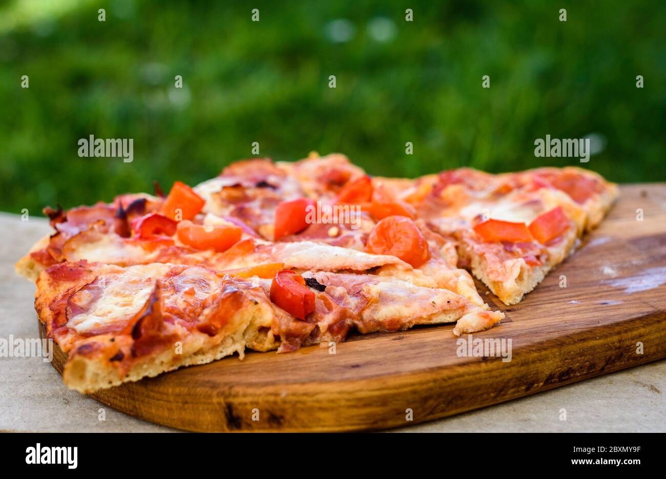 Making of homemade Italian pizza in fireplace brick oven. Making of traditional pizza in stone brick fireplace with fire wood and coals. Finished tast Stock Photo