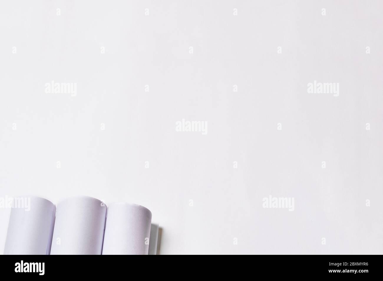 Rolled engineering drawings at white background with copy space. Stock Photo