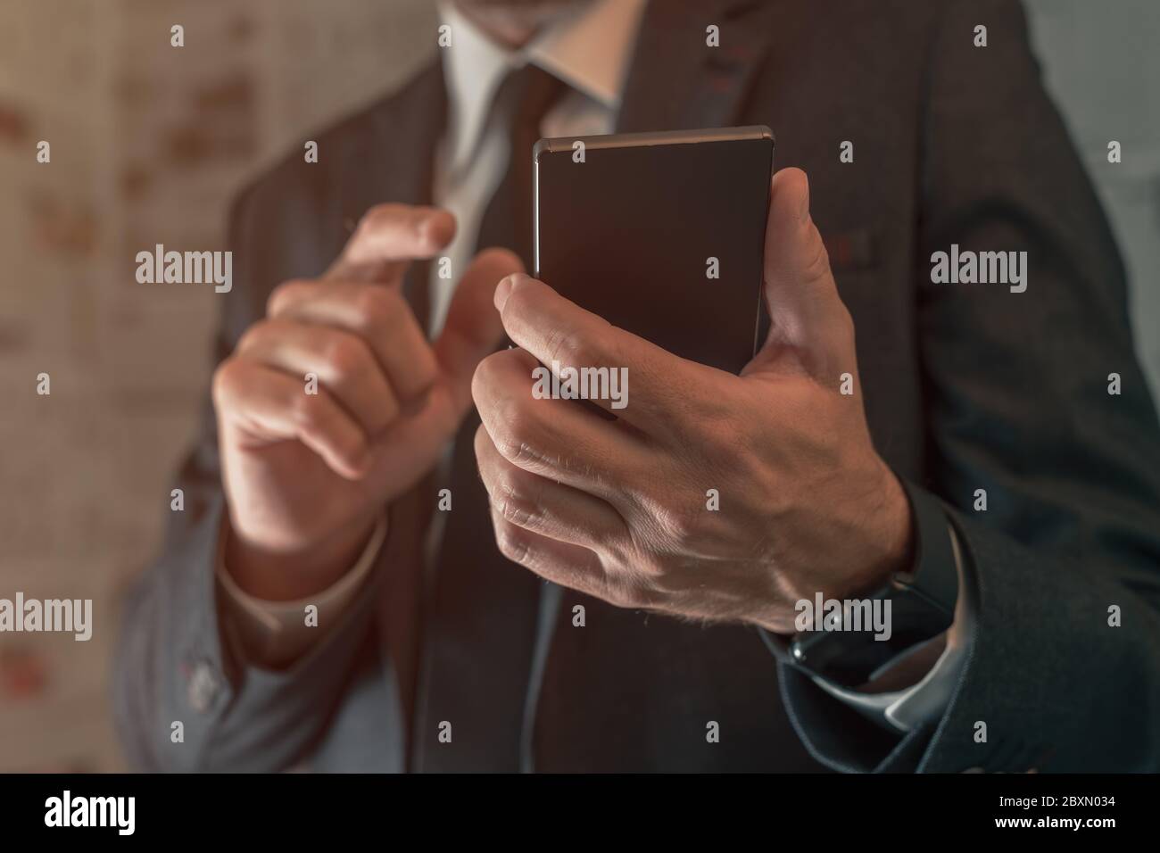 Businessman using mobile phone in fake news infodemic concept with tabloid newspaper pages in background Stock Photo