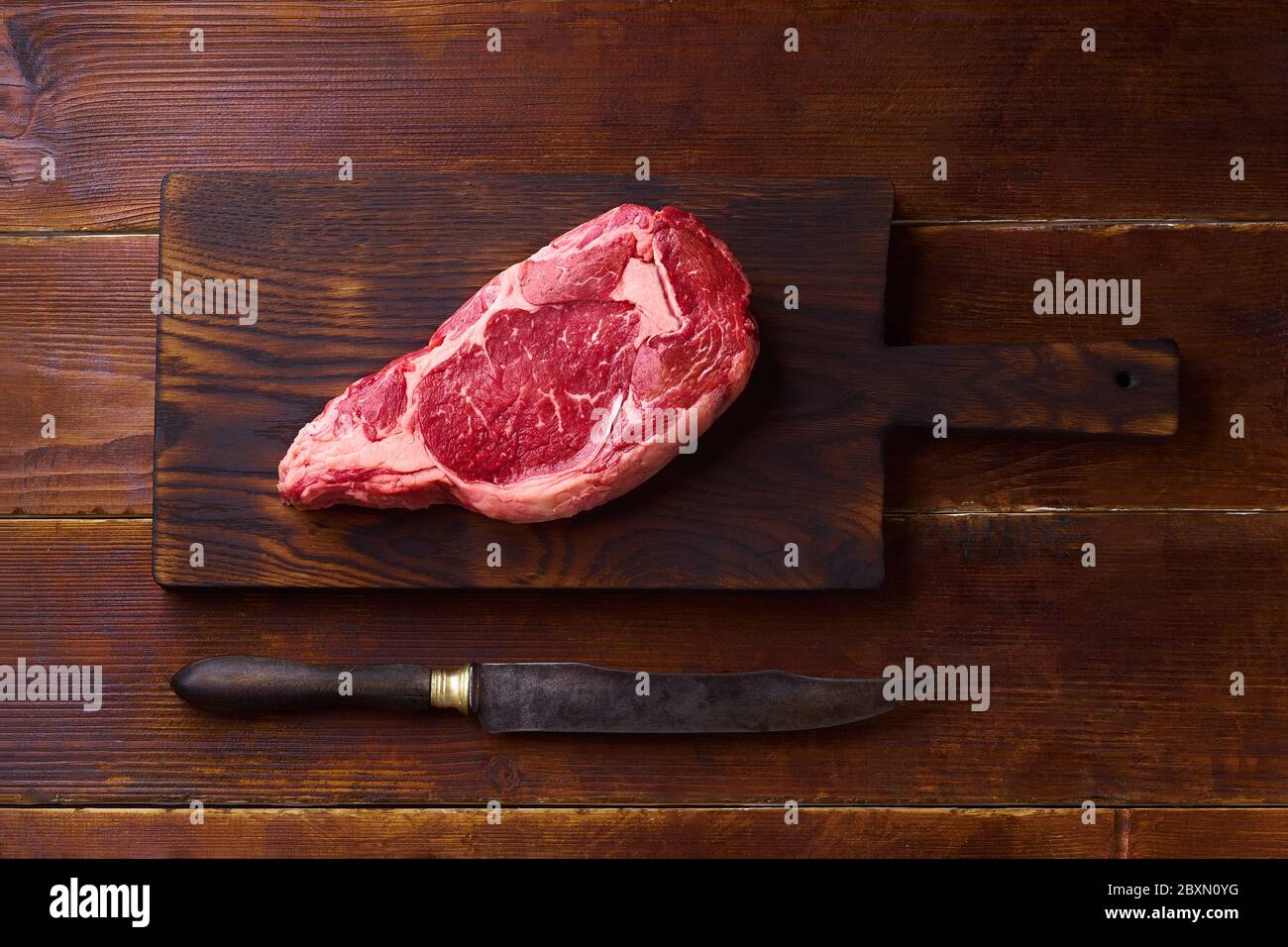 Top view Black Angus prime beef rib eye steak on cutting board wooden background copy space Stock Photo