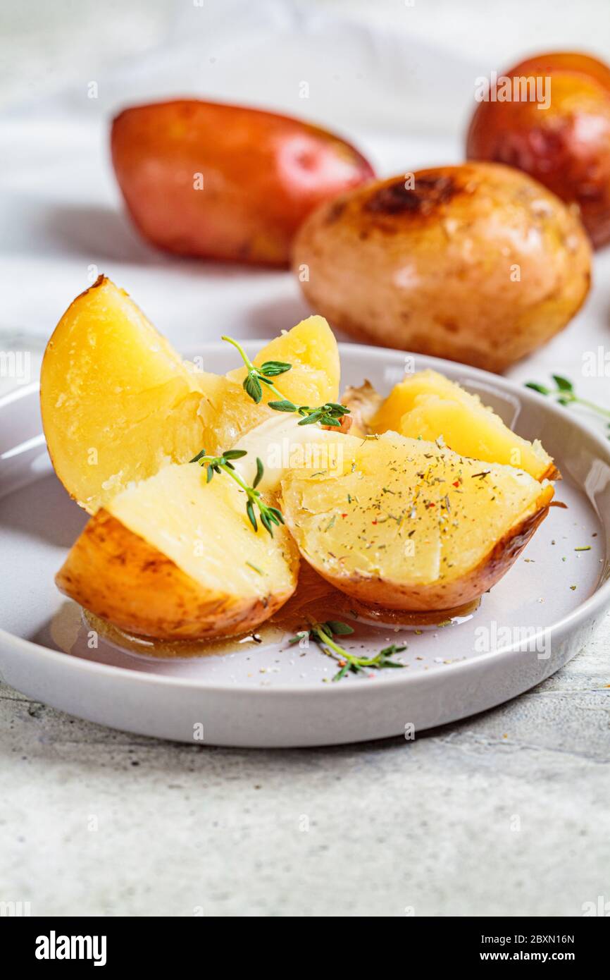 Baked potatoes with butter and thyme Stock Photo Alamy