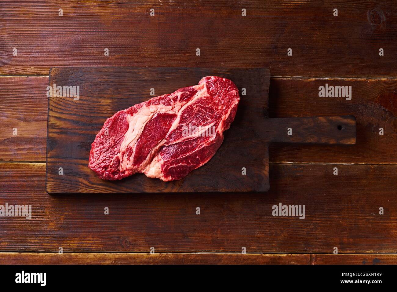 Top view Black Angus prime beef rib eye steak on cutting board wooden background copy space Stock Photo