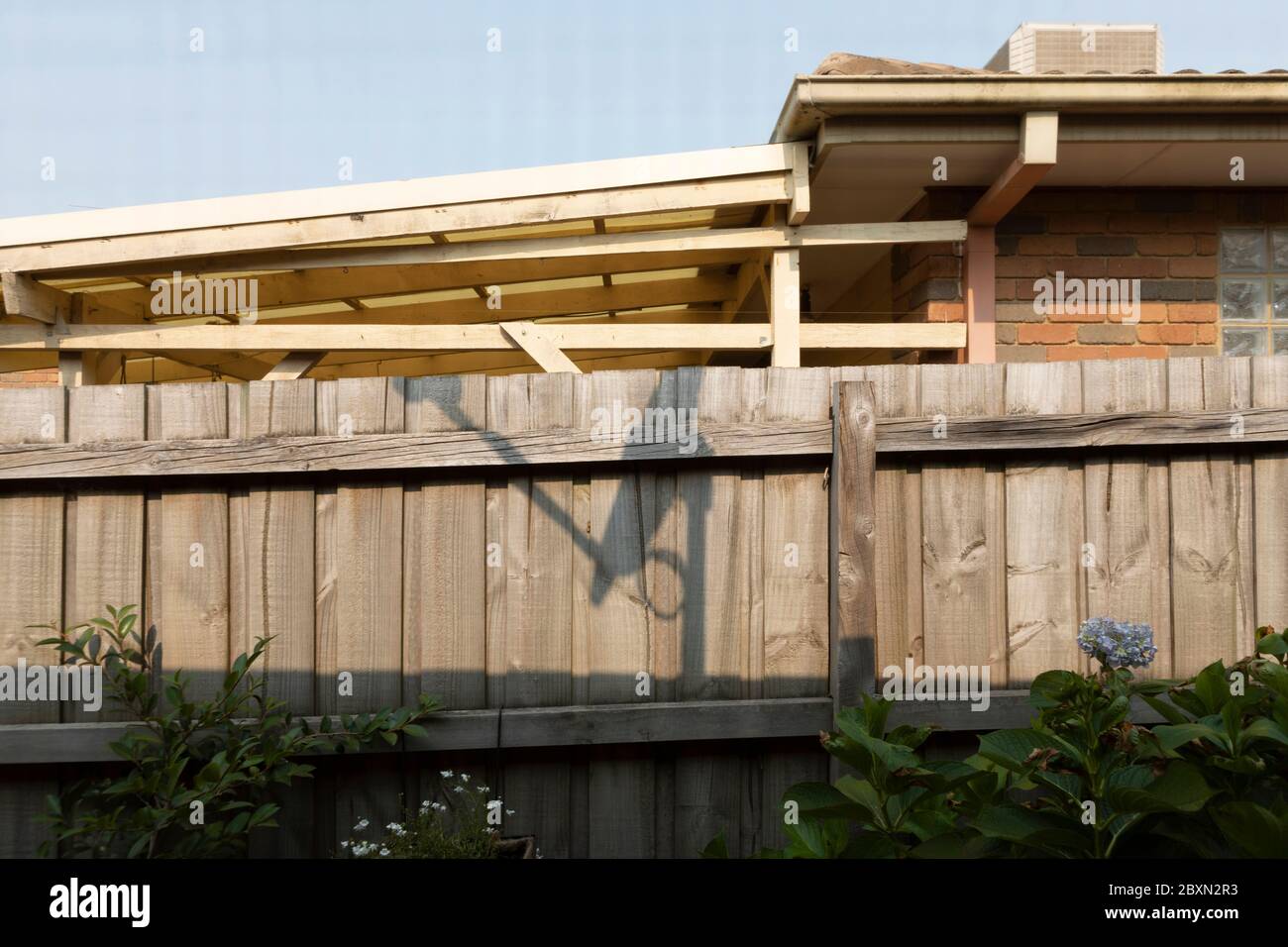 Satellite TV shadow cast on typical Australian residential neighborhood fence. Stock Photo