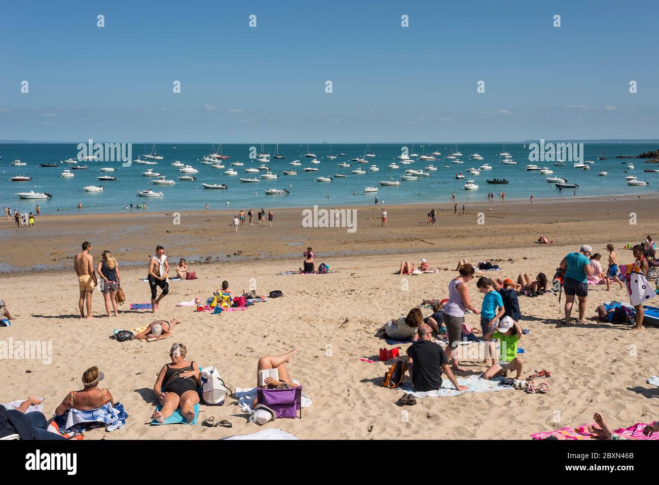 People enjoying summer day on sandy beach, Port Mer, Cancale, Brittany, France Stock Photo