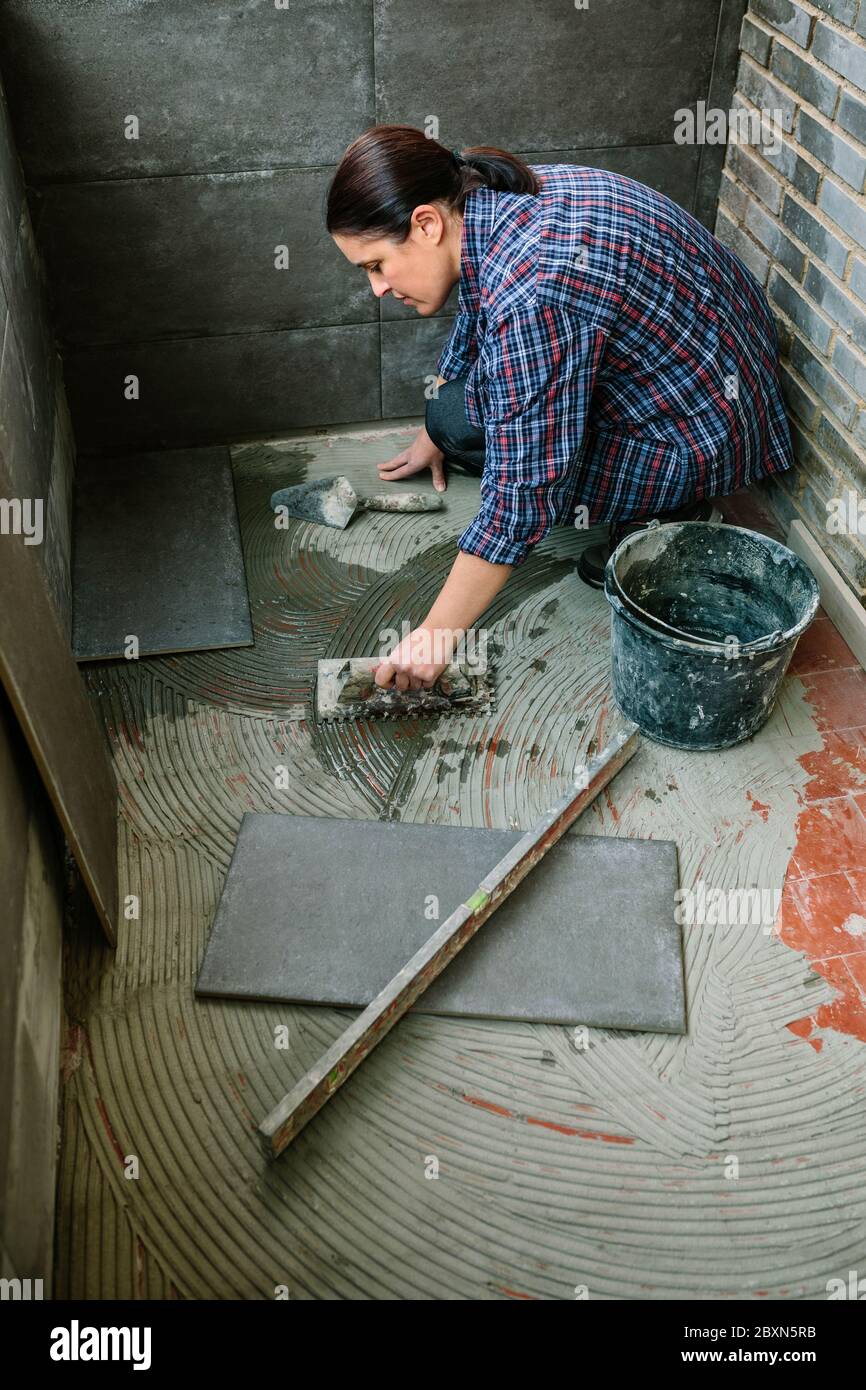 Female mason laying tiles on a terrace Stock Photo Alamy