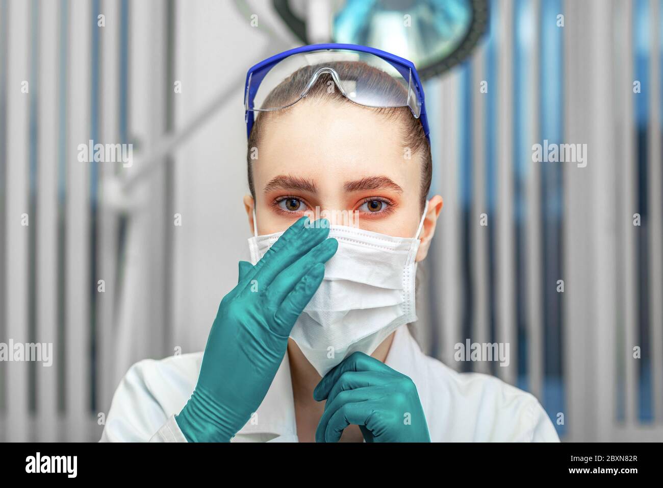 Female doctor puts on a mask, fight against the virus, personal protective equipment, masks