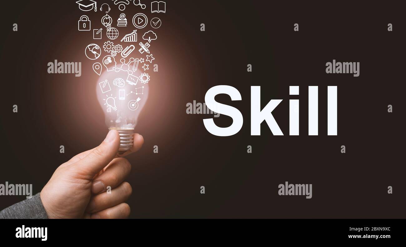 Skill concept. Abstract luminous light bulb in hands, knowledge, qualification and experience symbols fly out from it Stock Photo