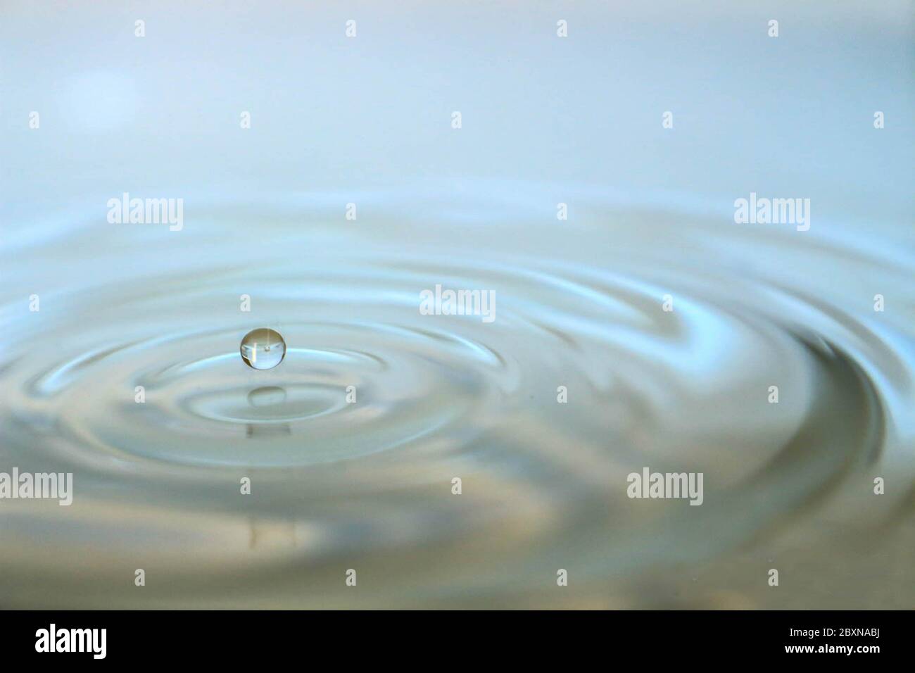 Water drop splash on white background and waves Stock Photo