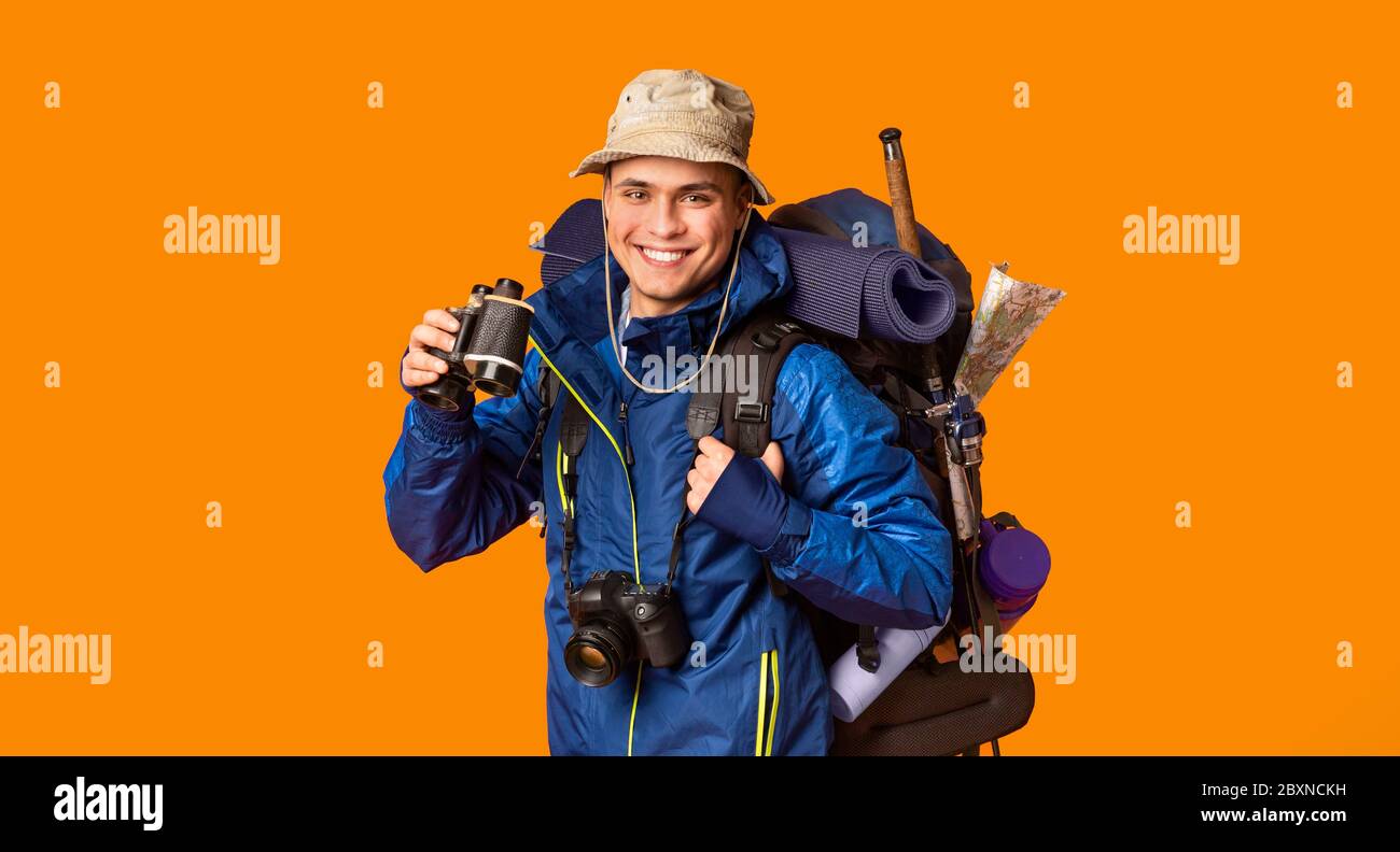 Happy backpacker enjoying his journey, holding binoculars Stock Photo ...
