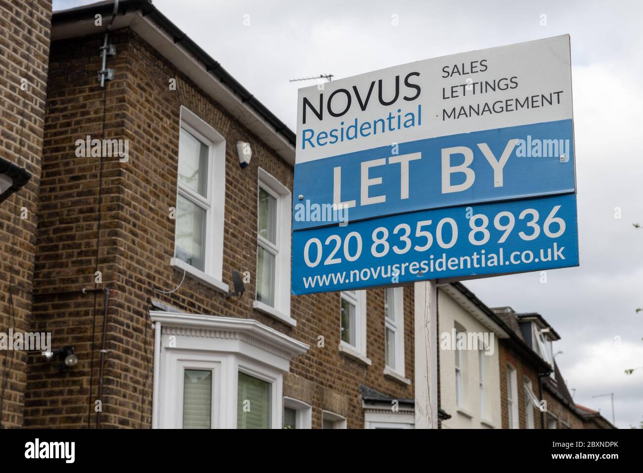 An estate agent house letting sign in front of a row of suburban houses, London. UK. Stock Photo