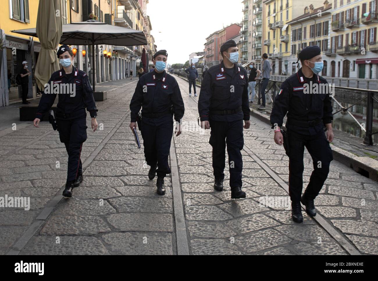 Police patrol wearing protective mask walk on the streets to keep social distance in Milan, Italy. Stock Photo