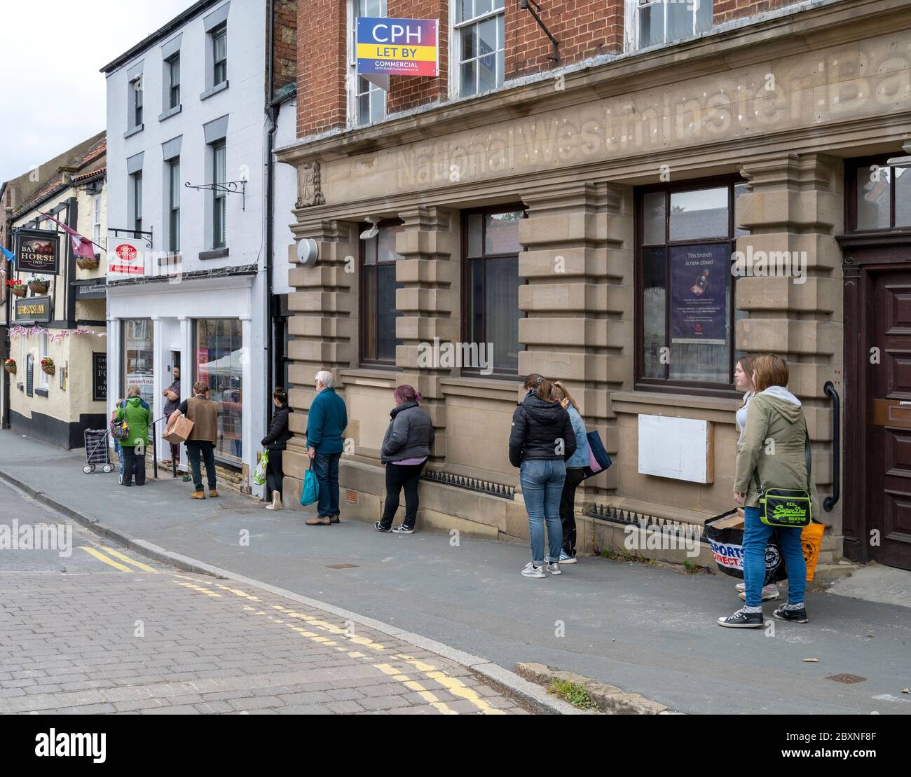 Social distancing outside Pickering post office Stock Photo