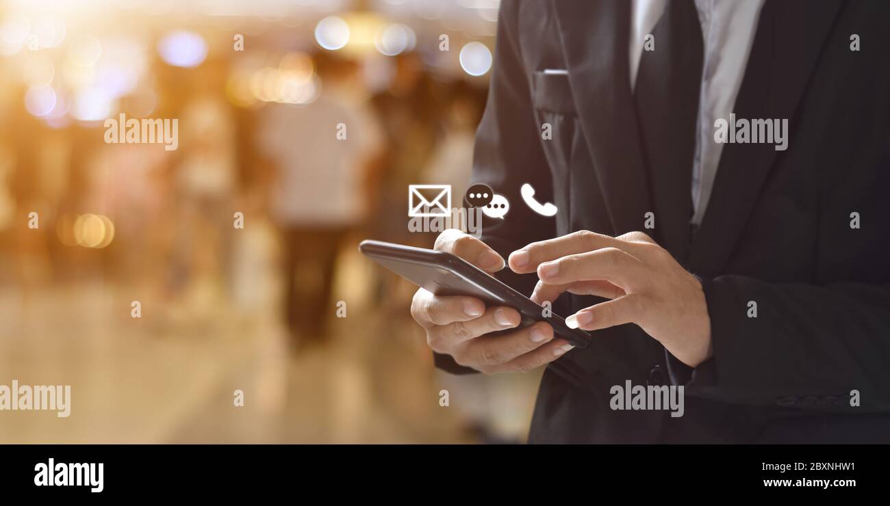 Businessman holding smartphone with ( message, calling, email ) icon. Concept of contact, support people or contacting information on business. Stock Photo