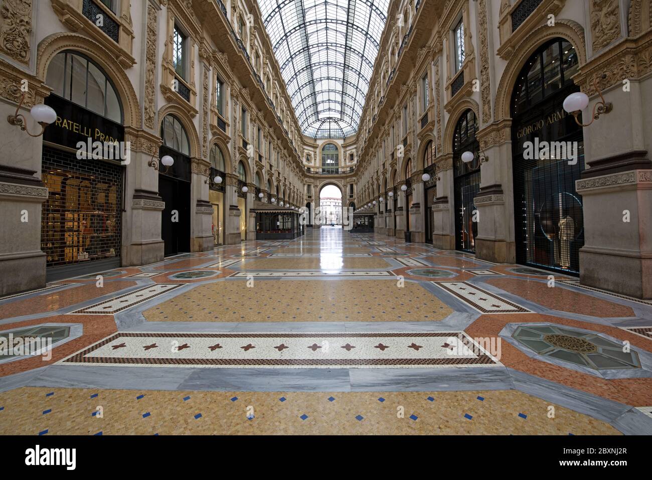 The emptiness of Galleria Vittorio Emanuele with shops closed during the lockdown caused by the Covid-19 in Milan, Italy. Stock Photo