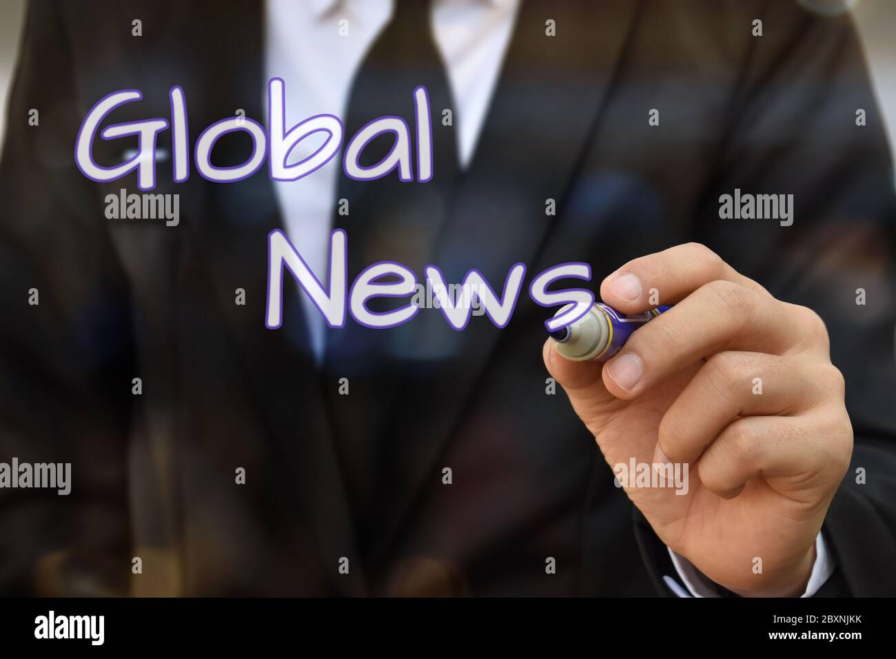 Businessman hand writing Global News on virtual screen. Idea for business and technology. Stock Photo