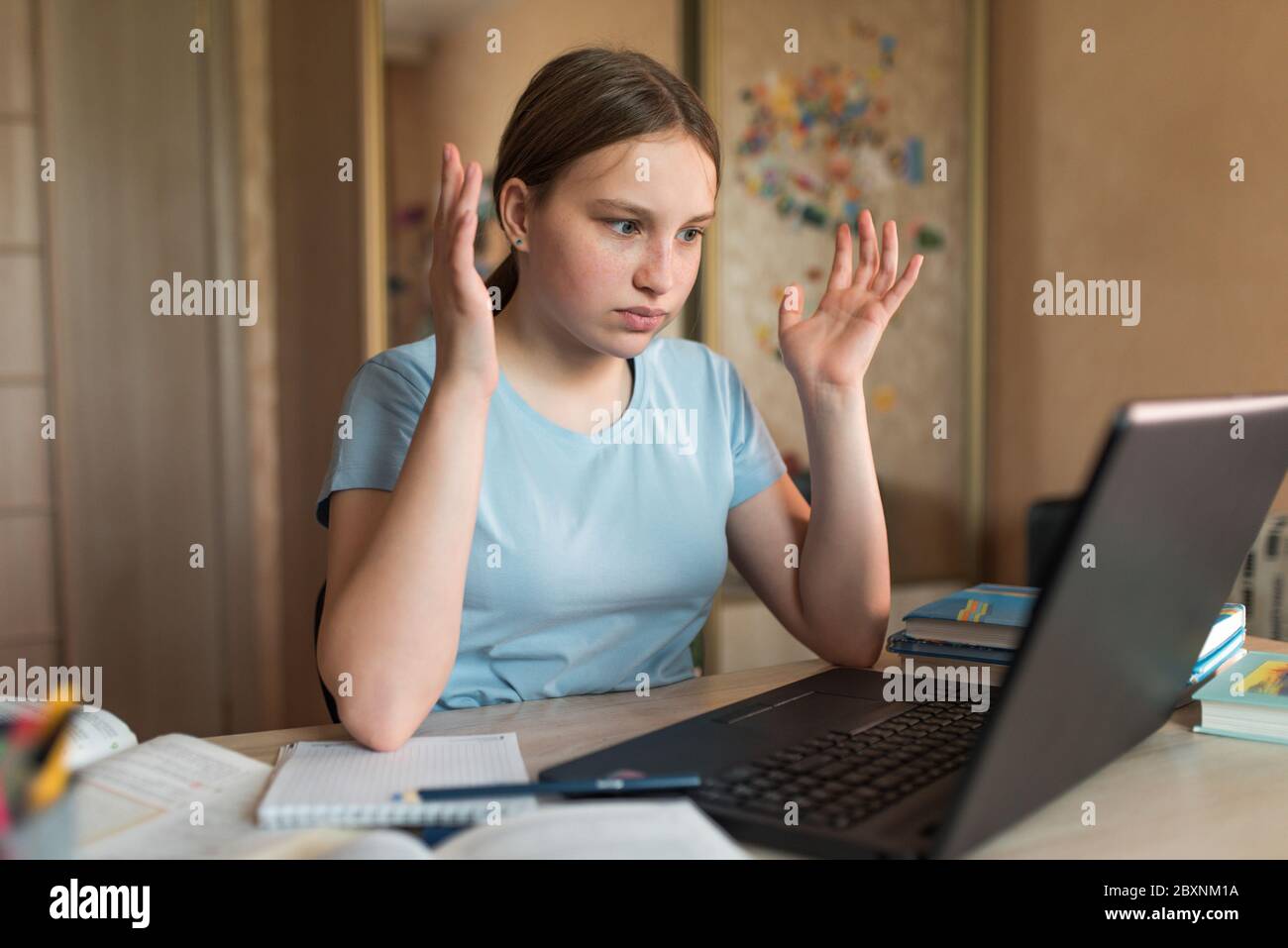 Teenager girl, surprised upset, misunderstanding embarrassment and indignation, home lessons with laptop, video training on Internet. Bad rating and Stock Photo