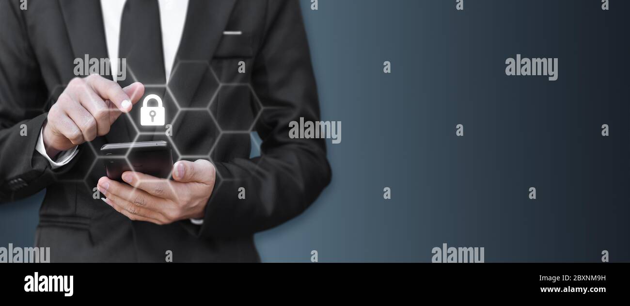 Closeup image of businessman pressing lock icon on mobile phone with copy space. Idea for personal data security. Stock Photo