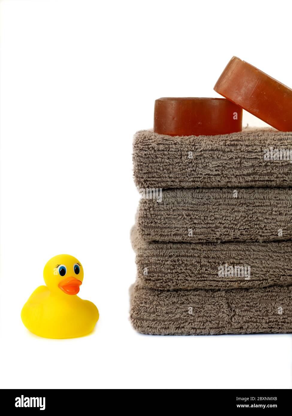 A stack of bath towels and a rubber duck isolated against a white background Stock Photo