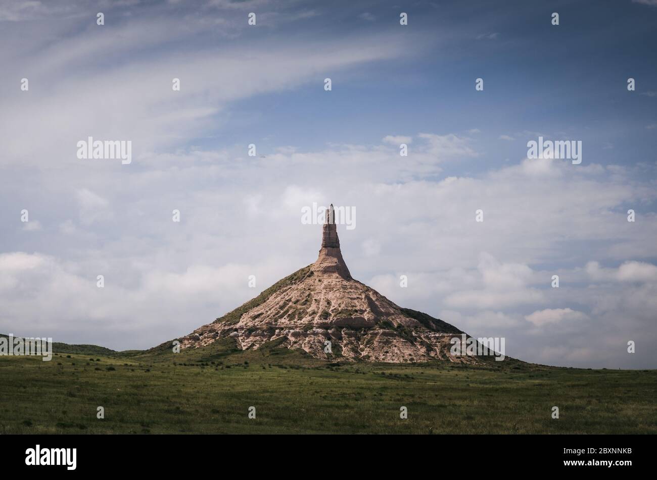 Cattle graze under Chimney Rock, a symbol used by pilgrims to mark the Oregon Trail. Stock Photo