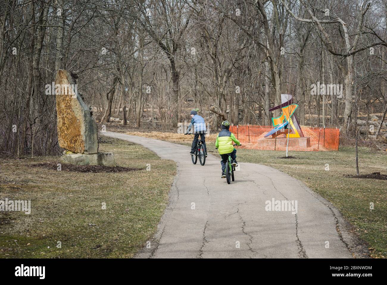 Schaumburg, Illinois USA - March 28, 2018 - The Chicago Athenaeum, International Sculpture Park, Two boys riding on bikes (for editorial use only) Stock Photo