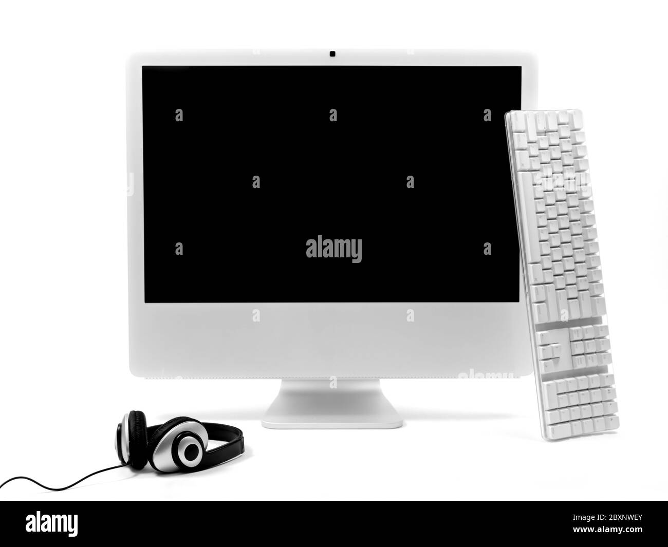 A desktop computer with a set of headphones isolaterd against a white background Stock Photo Alamy