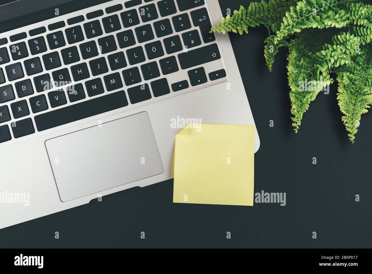 above view of empty yellow adhesive note on laptop keyboard Stock Photo
