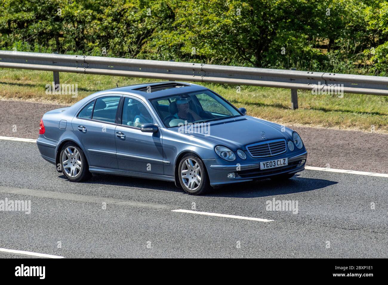 2003 blue Mercedes Benz E Class E320 CDI Avantgarde S210 Auto Estate Diesel Automatic; Vehicular traffic moving vehicles, cars driving vehicle on UK roads, motors, motoring on the M6 motorway highway Stock Photo