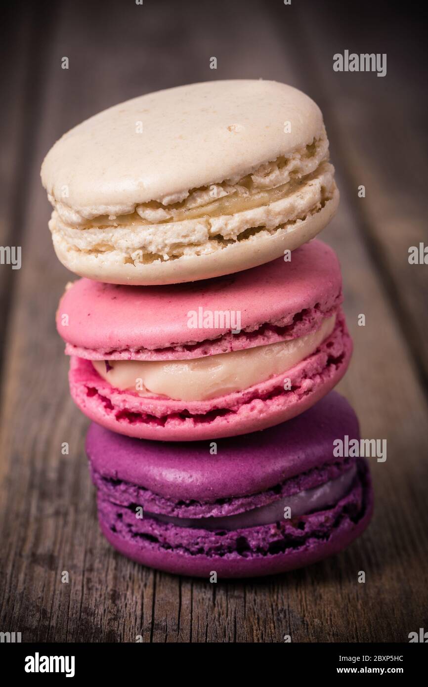 Assorted macaroons over old wood background. Vintage effect processing ...