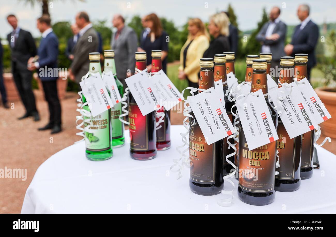 08 June 2020, Saxony, Meerane: Bottles of Meeraner liqueur "Mocca Edel",  "Edel Kirsch" and "Grün Weiss" (green and white) in the party colours of  the ministers stand on the edge of the
