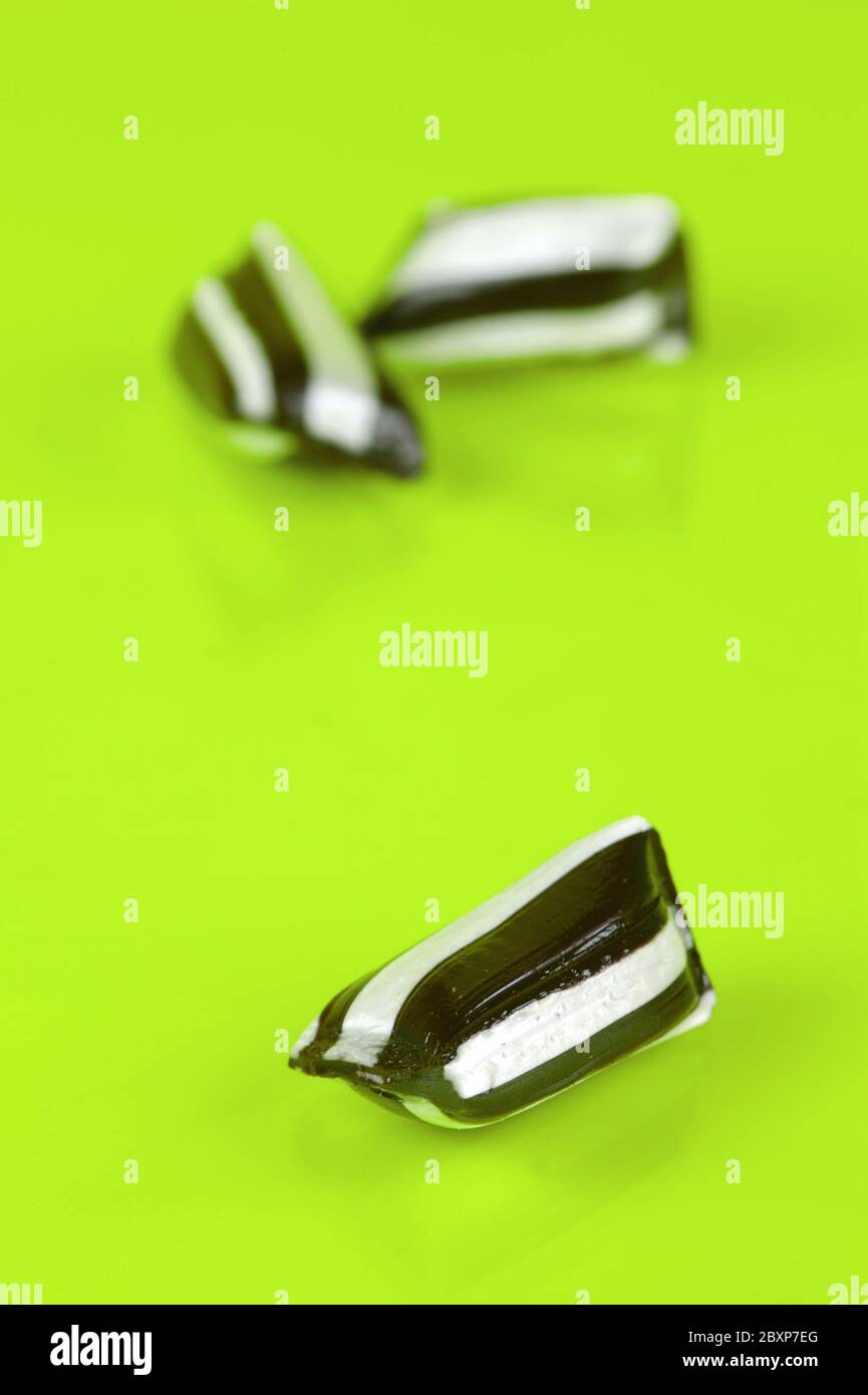Humbug lollies isolated against a yellow background Stock Photo