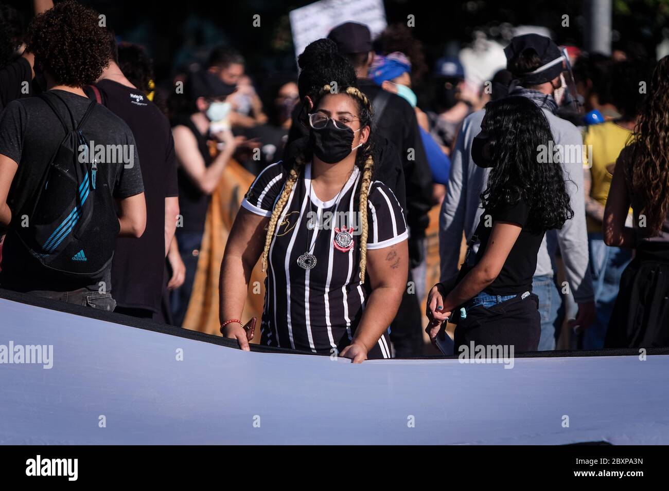 07 June 2020, Brazil, São Paulo: A woman in the Corinthians club jersey takes part in a protest against President Jair Bolsonaro. The demonstrations by Bolsonaro supporters - on the initiative of organised football fans - were the first to meet with resistance. Photo: Lincon Zarbietti/dpa Stock Photo