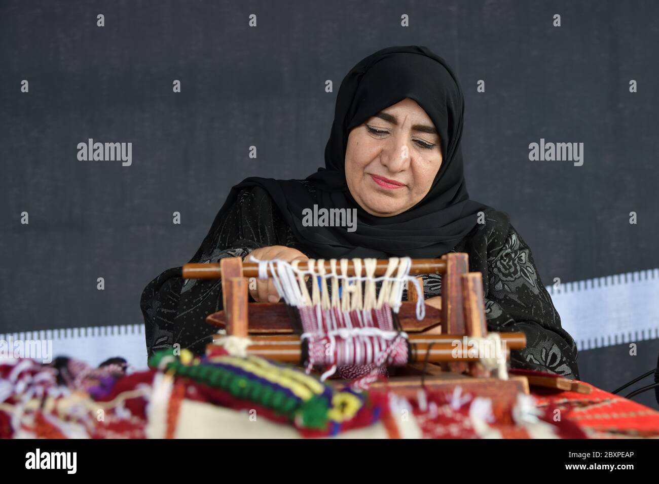 Moscow, Russia - July 14, 2018: A senior arabian woman makes a traditional sadu weaving. Qatar Stock Photo