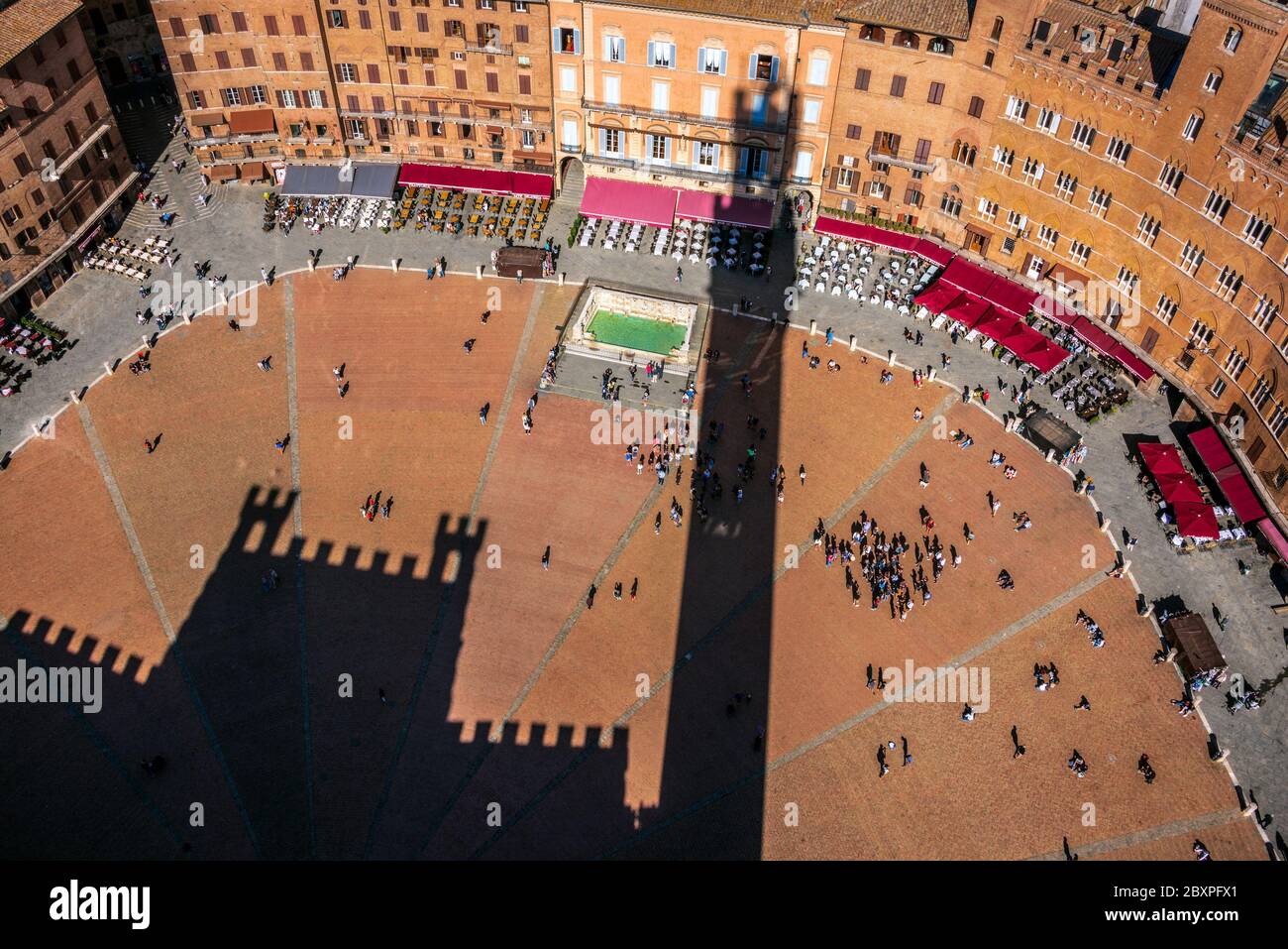 the town hall palace of Siena shot from high to bottom projected its shadows on the famous historical Campo city square Stock Photo