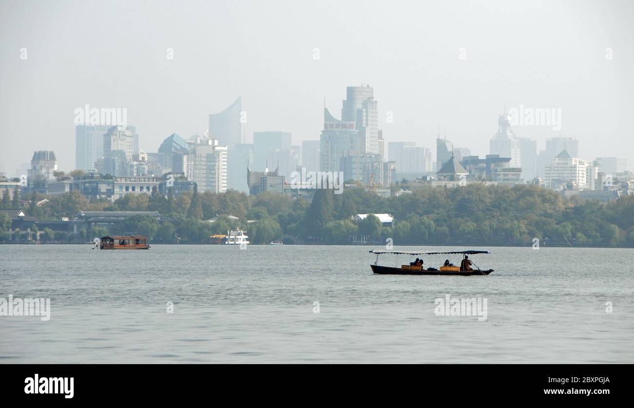 West Lake (Xi Hu) in Hangzhou, Zhejiang Province, China. Boats on West Lake with the city of Hangzhou behind. Stock Photo