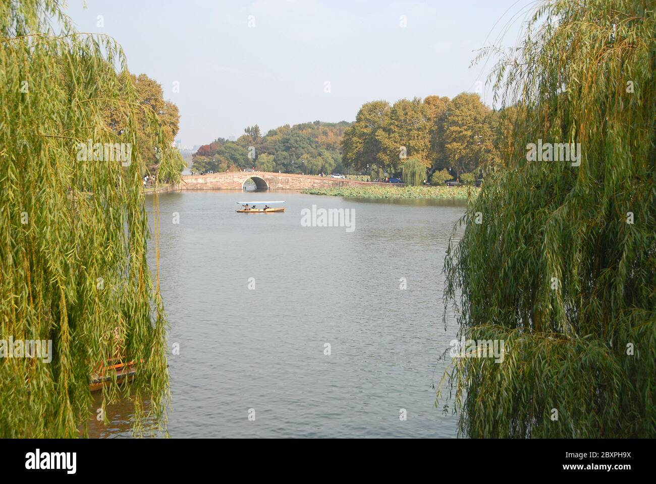 West Lake (Xi Hu) in Hangzhou, Zhejiang Province, China with willow trees. Taking a boat on West Lake, Hangzhou is popular with tourists Stock Photo