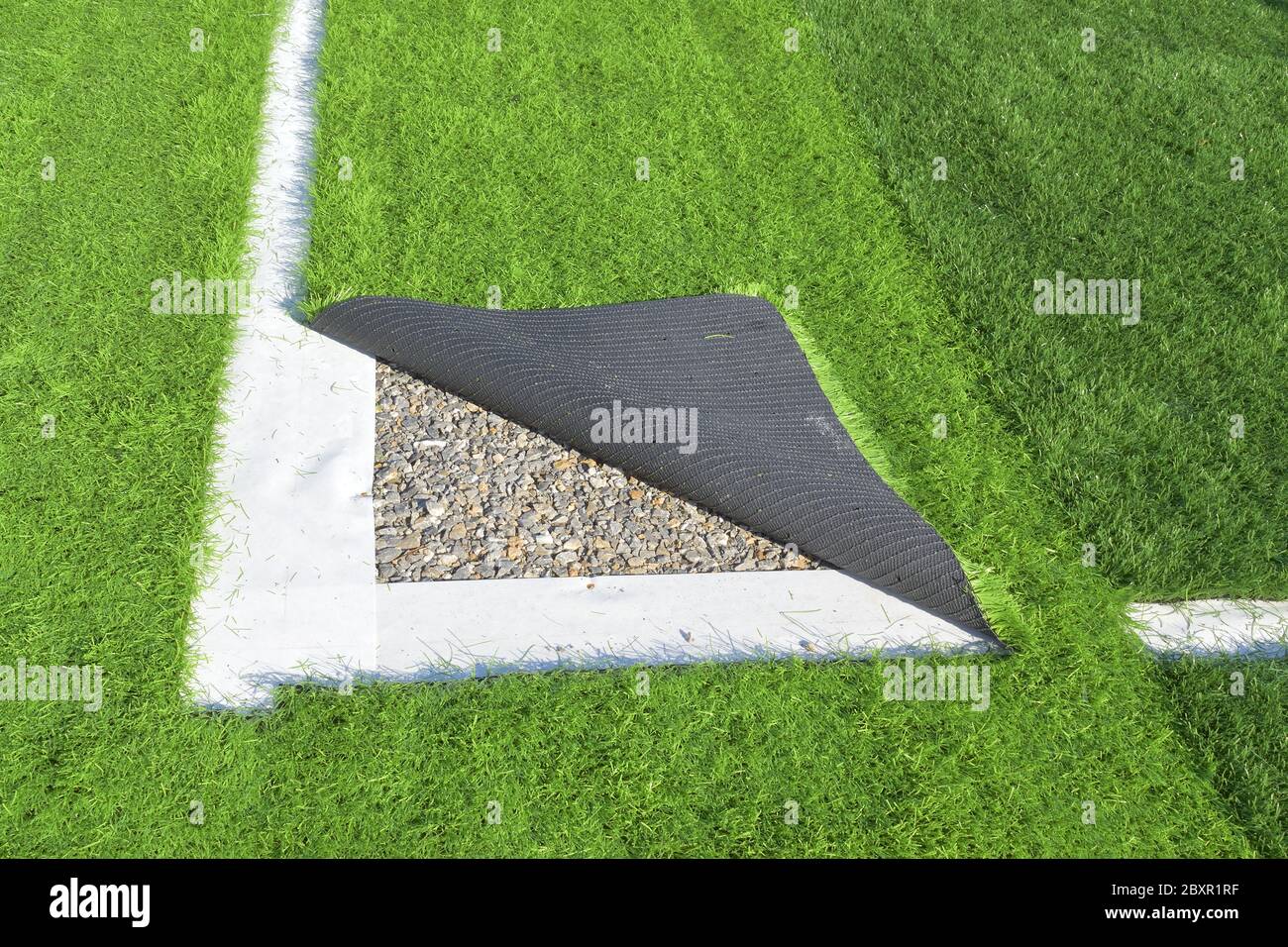 Between the dividers of the football field, artificial grass and the